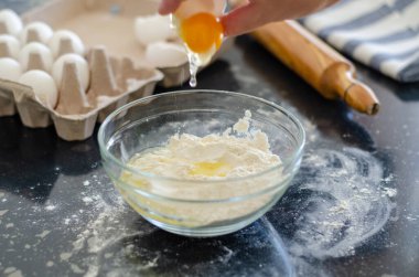 Kadın hamur yapmak için un kırıyor.