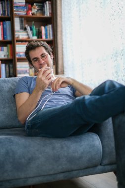 Genç adam, odadan ailesiyle akıllı telefondan konuşuyor. Duygulu ve gözyaşları içinde.