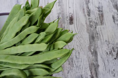 Beyaz masada bir grup yeşil fasulye.