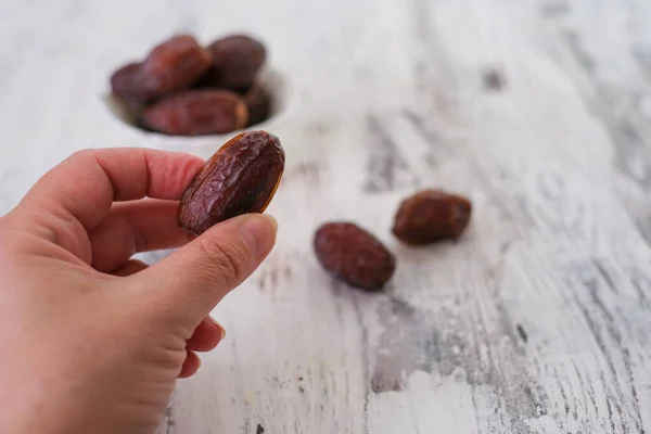 Ripened dates are  in the bowl and her hand . An important fruit in islamic country.  A healthy and nutritious food for breaking fast during holy month of Ramadan.