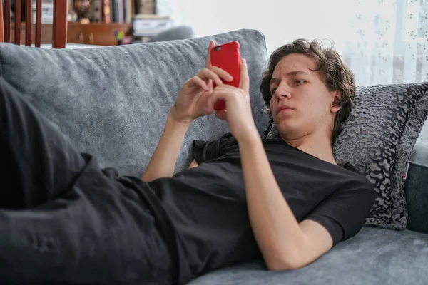 Caucasian teenager  is learning from on mobile phone at home in corona days.