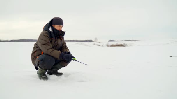 Fisherman ice fishing on the river. A man on winter fishing. — Stock Footage Fisherman ice fishing on the river. A man on winter fishing. Stock Footage