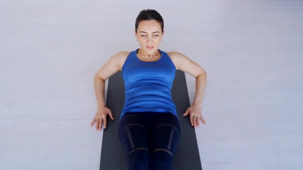 Pretty brunette performs an exercise on the abdominal muscles. — Stock Footage Pretty brunette performs an exercise on the abdominal muscles. Stock Footage