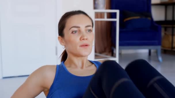 Pretty brunette performs an exercise on the abdominal muscles. — Stock Footage Pretty brunette performs an exercise on the abdominal muscles. Stock Video