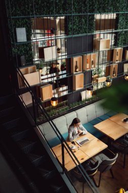 Kafede bir bilgisayarda çalışma gözlük ile genç iş kadını. İş, online iş kavramı.