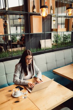 Bir bilgisayarda çalışan gözlük ile genç iş kadını.