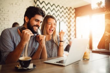 Laptop ve kafede kredi kartı ile online alışveriş yaparken sürpriz genç Çift.