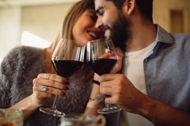 İki bardak kırmızı şarap ile gündelik kıyafeti kafede tarihte tıklatması. Romantik anlar sahip çift.