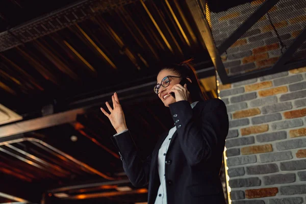 Businesswoman executive working with mobile phone and waving to her friend.