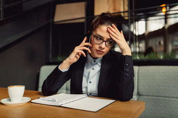 Mulher Negócios Preocupada Com Óculos Segurando Telefone Inteligente Tomando Notas — Fotografia de Stock