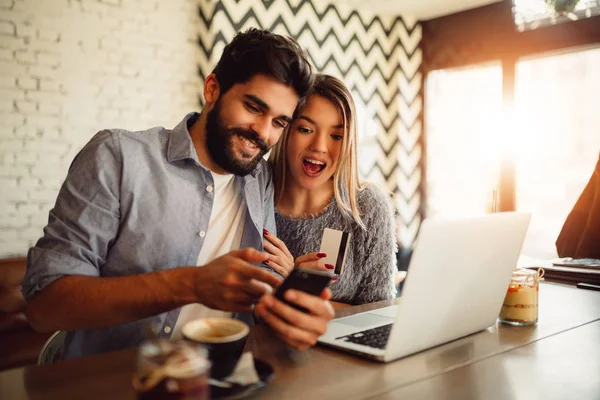 Genç çift kafede alışveriş online. Adam banka hesabını kontrol.