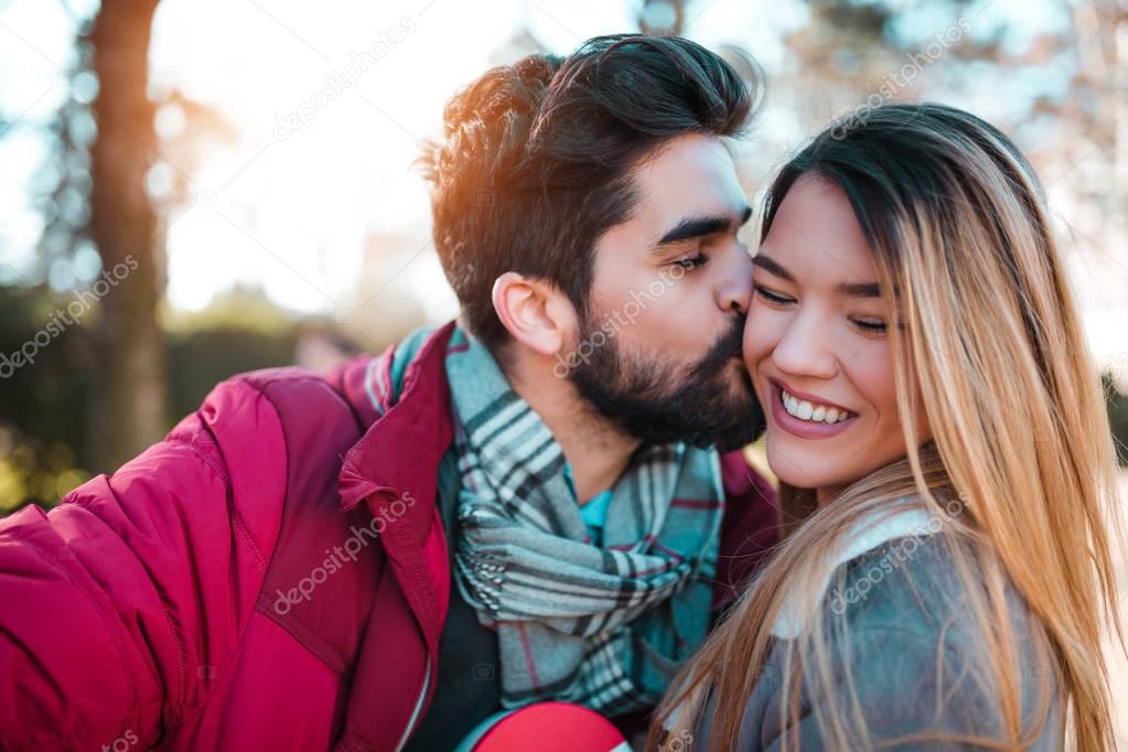 Man hugs a happy woman. Young couple in love on Valentine's day. International Women's Day. Close up.