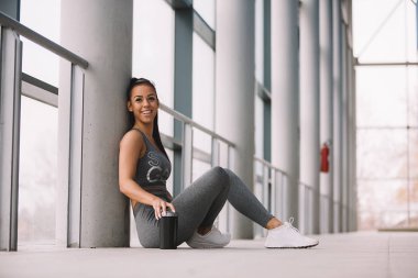 Floar, zor egzersiz yaptıktan sonra dinlenme ayağı üzerine eğilerek üzerinde oturan uygun kız.