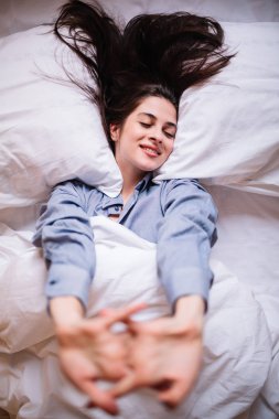 Modern apartmandaki güzel genç kadın uyandıktan sonra geriniyor..