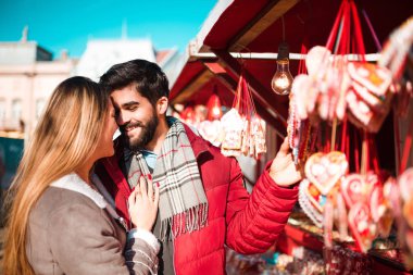 Romantik Çift ayakta gülümseyen ve bazı tatlı lolipop satın sokakta. Yıldönümü, Sevgililer günü.