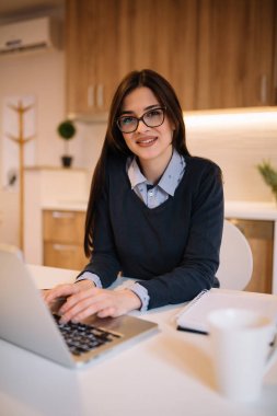 Dizüstü bilgisayar kullanarak gözlük güzel uzun saçlı kadın. Serbest çalışma kavramı.