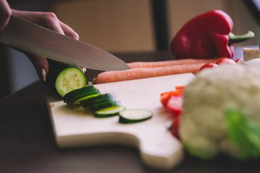 Kız el kesim salatalık sırasında kapatın.