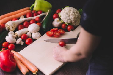 Kiraz domates kesme ve salata çatalı eller.