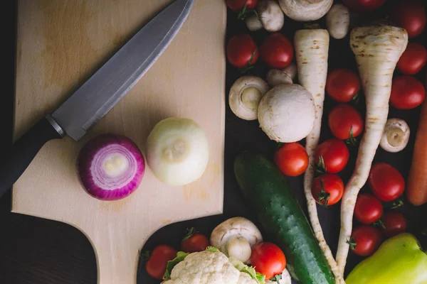 Ahşap tahta üzerinde sebze ile çevrili soğan Üstten Görünüm.