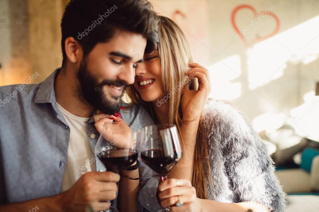 Couple clinking glasses with red wine. Couple celebrating anniversary, Valentine's day or International woman's day.