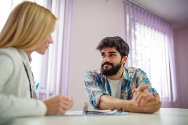Doktorun ofisinde genç yakışıklı adam.
