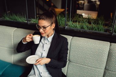 Genç işkadını kafeteryada kahve içme.