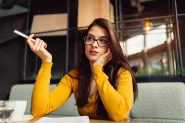 Genç güzel kız notları kafeteryada yapıyor.