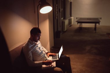 İşadamı dizüstü bilgisayarda gece geç saatte ofisinde çalışıyor..