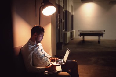 Gece geç saatlerde bilgisayar ofiste çalışan mutlu iş adamı. Yazılı notlar.