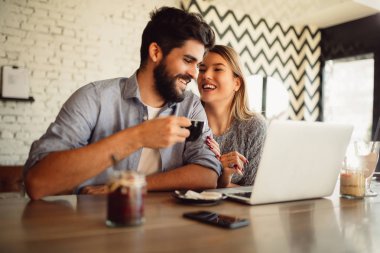 Dizüstü bilgisayarda internet sörf kafeteryasında genç Çift.