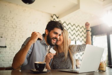 Mutlu çift kafeteryada alışveriş online.