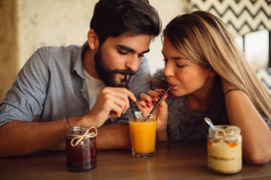 Hoş bir çift bir tarih Café portakal suyu bir bardak paylaşımı