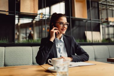Cep telefonunuzda konuşurken gözlük giyen genç kadın.