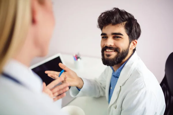 Genç Gülümseyen Erkek Doktor Arkadaşı Ile Konuşurken Portresi — Stok fotoğraf