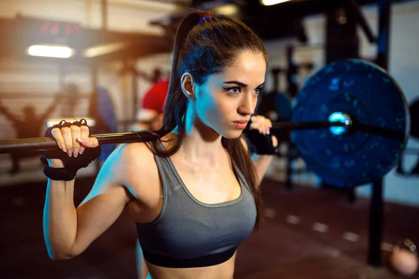 Yakın çekim yapmaya motive odaklı çekici genç fitness kadının kadroları spor salonunda egzersiz.