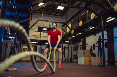 Çekici kaslı adam ile ağır ipler çalışma dışarı. CrossFit.