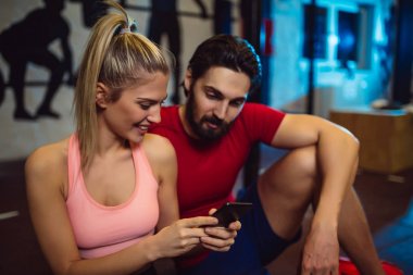 Çift smartphone kullanarak spor salonunda.