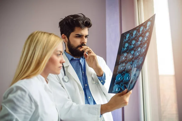 Two doctors discussion a method with patient treatment, with mammogram film x-ray.