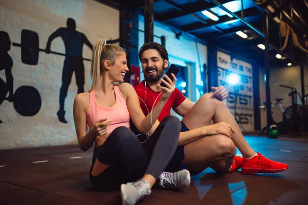 Çift modern crossfit spor salonunda müzik smartphone tam anlamıyla uyum.
