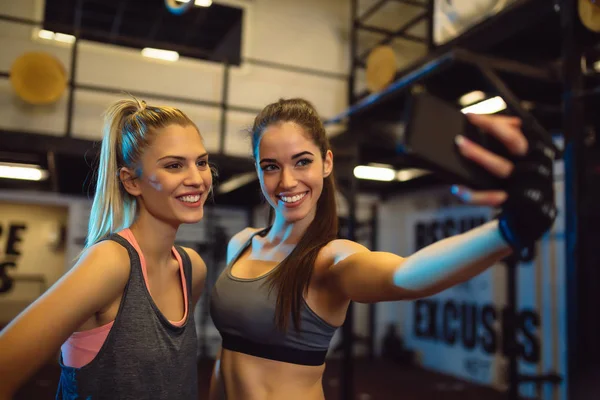 Portrait of young women taking a selfie in the gym. — Stock Photo, Image