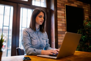 Kablosuz internet'e bağlanan dizüstü bilgisayar aygıt uzaktan çalışan kadın metin yazarı gülümseyerek. Sosyal ağlarda kafede oturan arkadaş sohbet çekici kadın freelancer zekâ iyi bir ruh hali