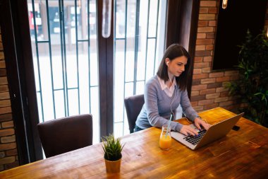 Dizüstü bilgisayarda çalışan genç bir kadın