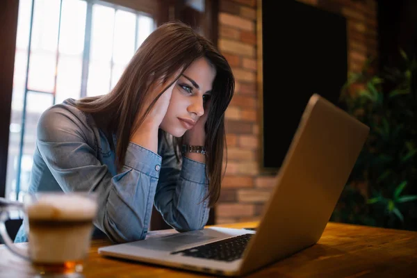 Mujer joven preocupada mira el ordenador portátil —  Fotos de Stock