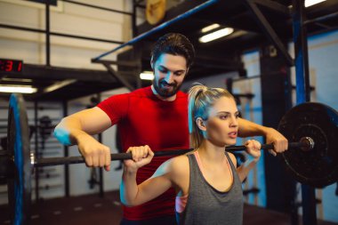  spor salonunda eğitmeni olan kadın