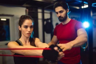  spor salonunda eğitmeni olan kadın