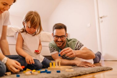 Genç aile eğlenceli sahip yatak odasında oynarken zaman