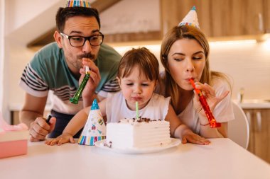 Sevimli küçük kız küçük doğum gününü ailesiyle birlikte yaşıyor ve o pasta bir doğum gününde mum esiyor