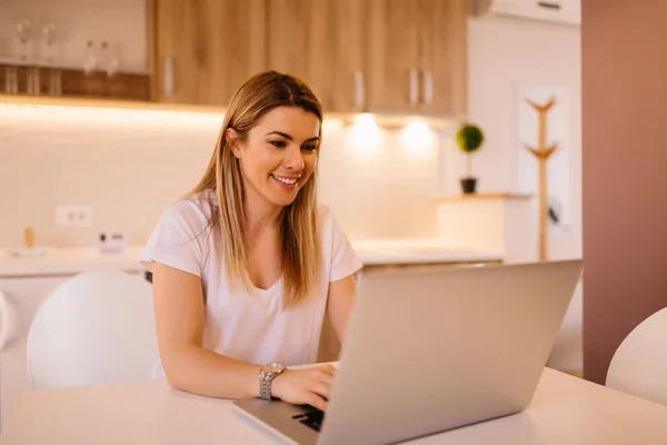 Genç sarışın iş kadını o oturma onun odasında iken onu laptop üzerinde çalışıyor