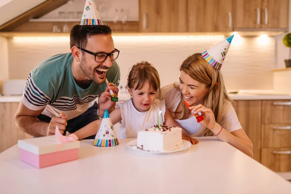 Cute little girl got gift and birthday cake with candle from her parents for her birthday