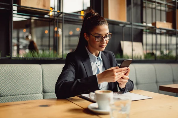 Hermosa Mujer Negocios Con Gafas Está Utilizando Teléfono Inteligente Mientras — Foto de Stock